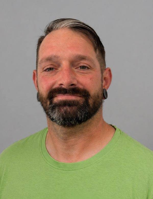 Portrait von Stefan Kirsten, Ansprechpartner und Mitarbeiter von Gartenkonzepte Dresden, in grüner Arbeitskleidung