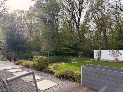 Individuell gestalteter Garten in Sachsen mit modernem Holzhochbeet, Pflanzflächen, Gartenteich und Trittsteinweg – Gartenbau Gartenkonzepte