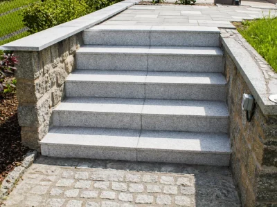 Elegante Granittreppe mit flankierender Natursteinmauer als repräsentativer Garteneingang – Gartengestaltung Pirna